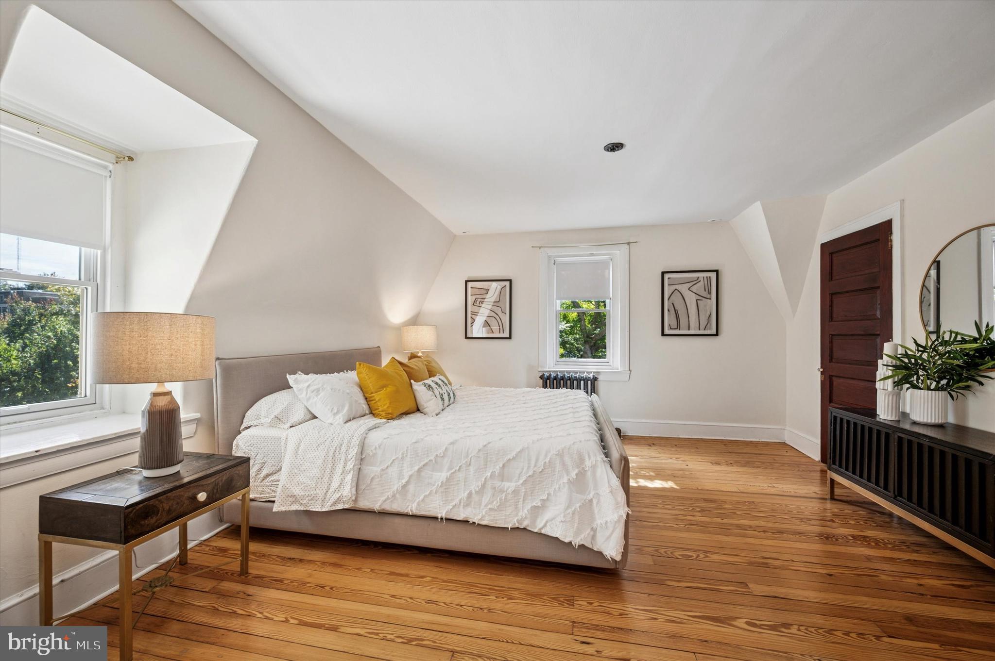 200 East Gravers Lane Philadelphia, PA 19118 - Photo 42 of 57 a bedroom with a bed wooden floor and a lamp on table with wooden floor