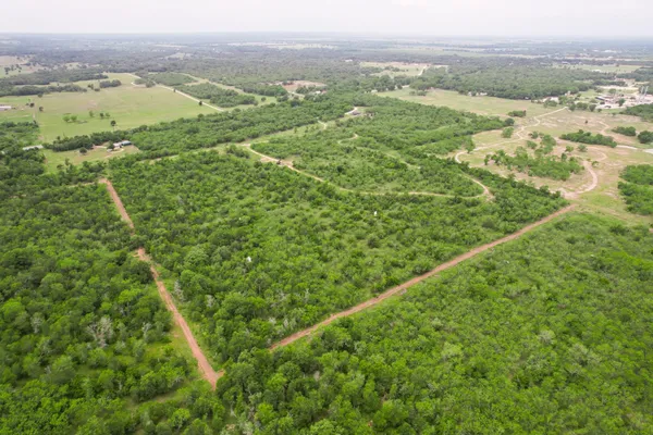 an aerial view of residential houses with outdoor space and trees