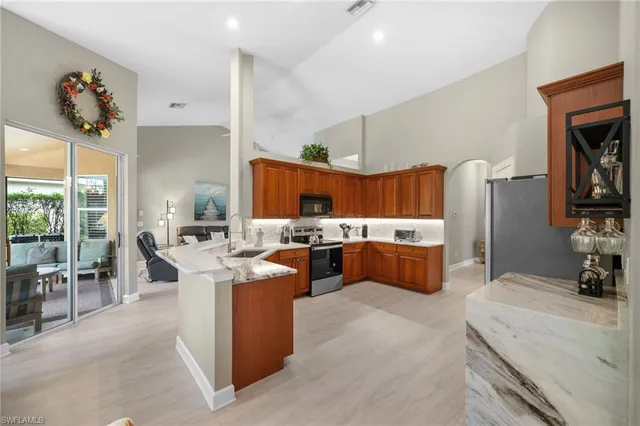 a living room with furniture a table and kitchen view