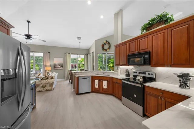 a kitchen with stainless steel appliances granite countertop a sink dishwasher stove and refrigerator