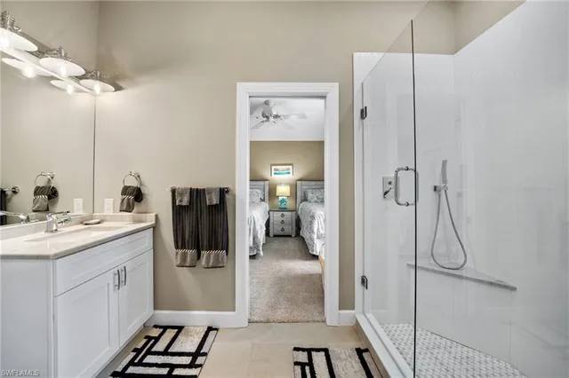 a en suite bathroom with a shower sink and mirror