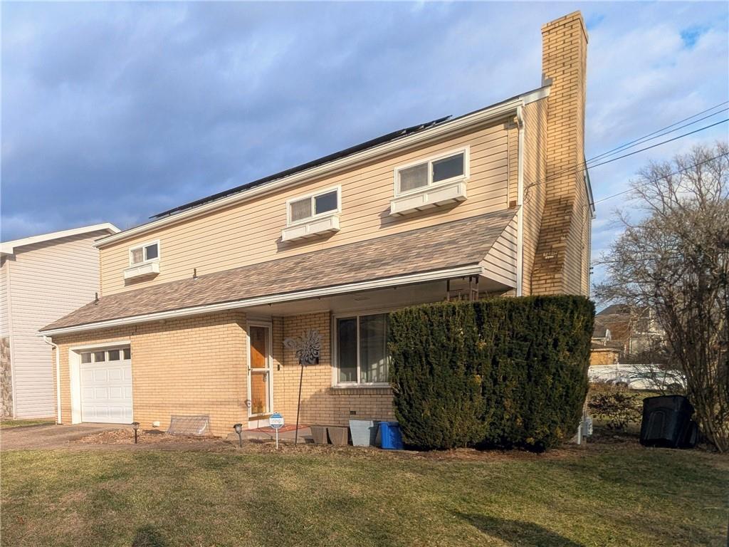 a front view of a house with a garden