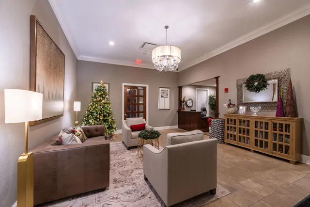 a living room with furniture a chandelier and a flat screen tv