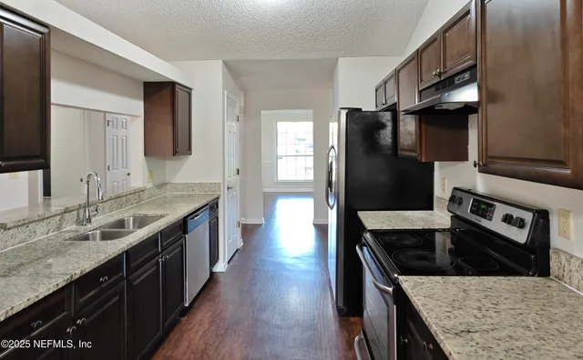 a kitchen with stainless steel appliances granite countertop a stove a refrigerator and a sink