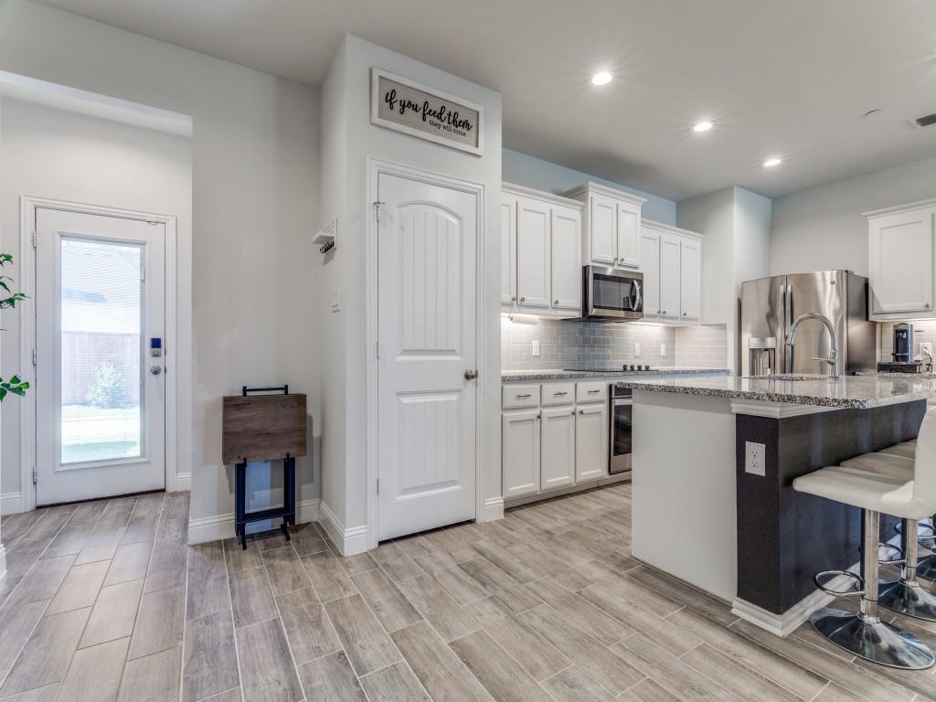 5944 Bursey Road Watauga, TX 76148 - Photo 8 of 25 a kitchen with kitchen island granite countertop a sink cabinets and wooden floor