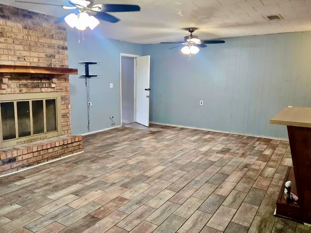 a view of an empty room with a chandelier fan