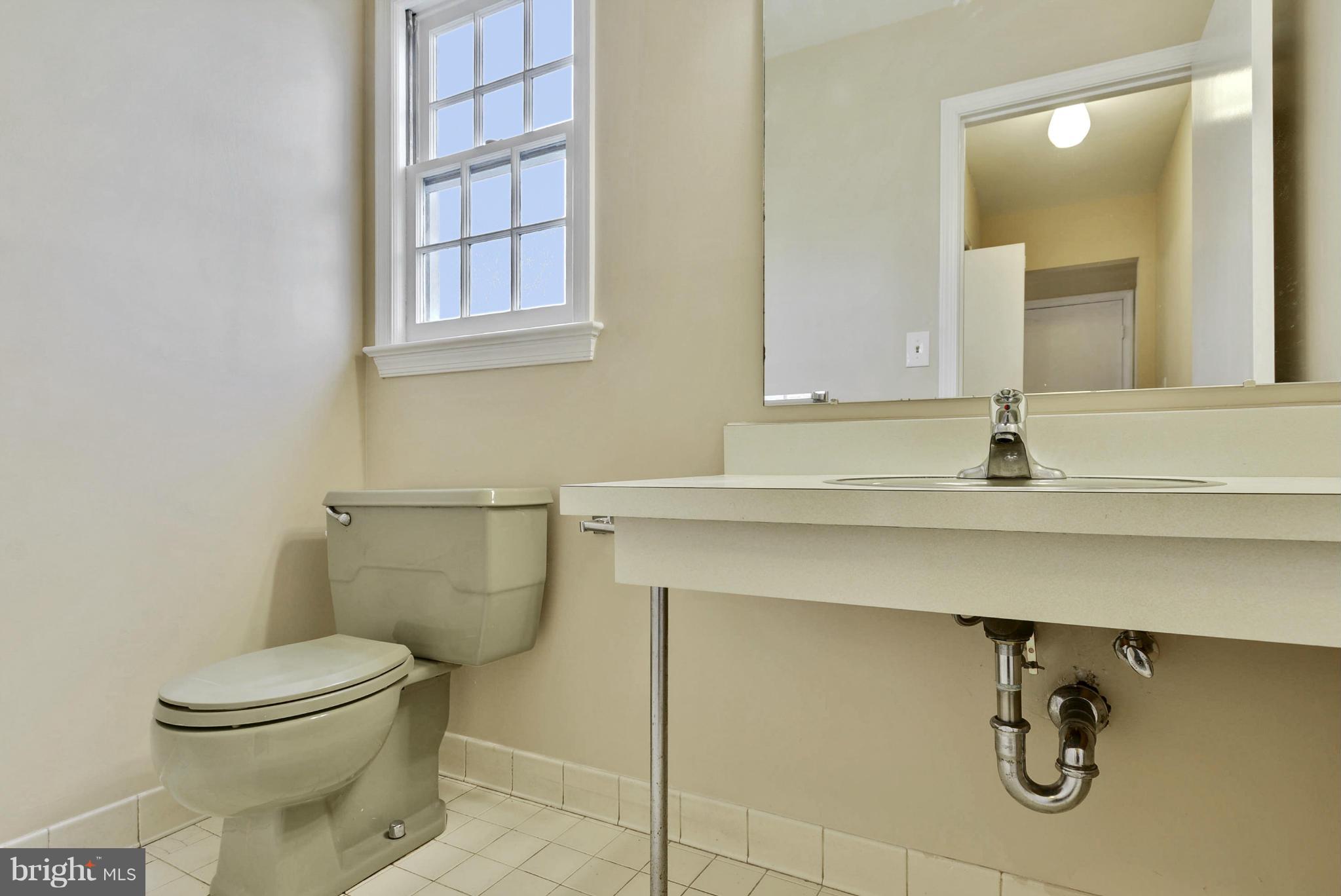 9503 Flower Avenue Silver Spring, MD 20901 - Photo 11 of 30 a bathroom with a sink a toilet and mirror
