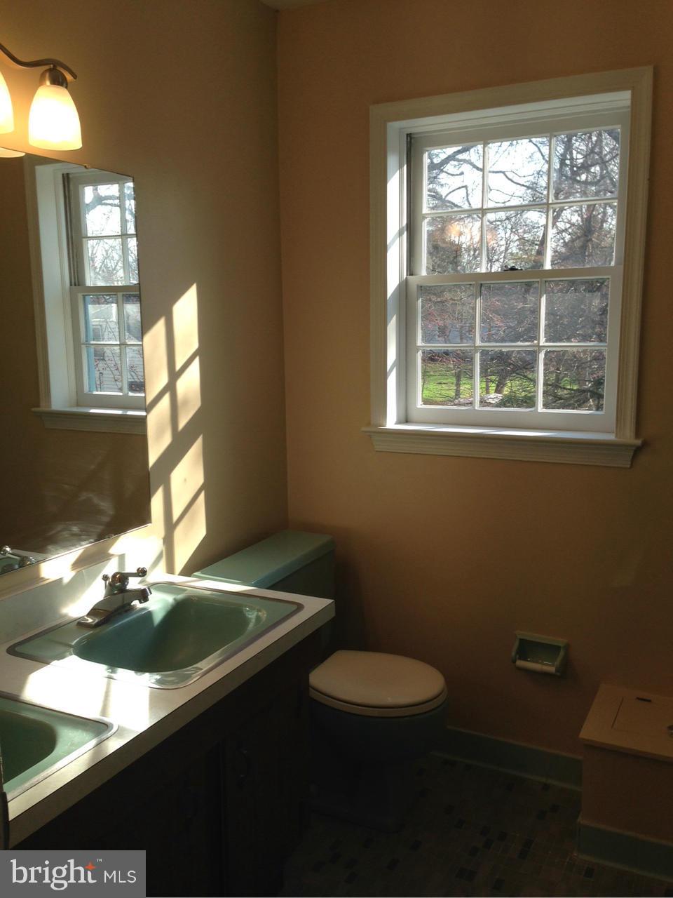 9503 Flower Avenue Silver Spring, MD 20901 - Photo 23 of 30 a bathroom with a sink mirror vanity and a toilet