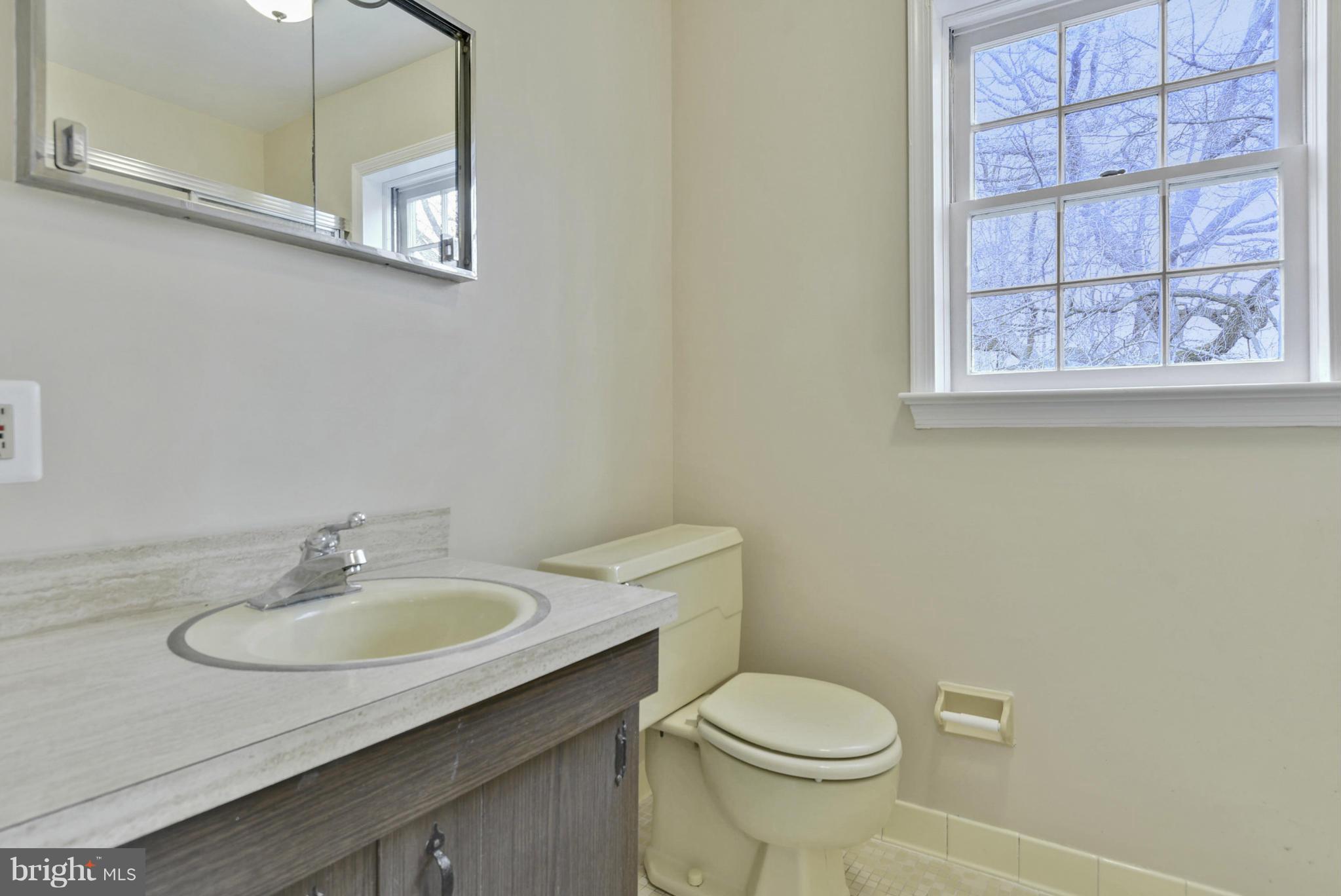 9503 Flower Avenue Silver Spring, MD 20901 - Photo 28 of 30 a bathroom with a sink a mirror and a toilet