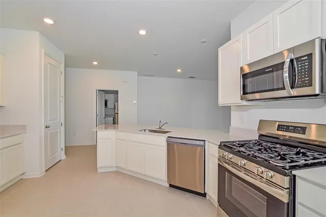 a kitchen with stainless steel appliances white cabinets and a stove top oven