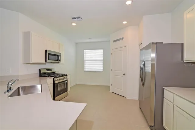 a kitchen with stainless steel appliances granite countertop a refrigerator and a sink