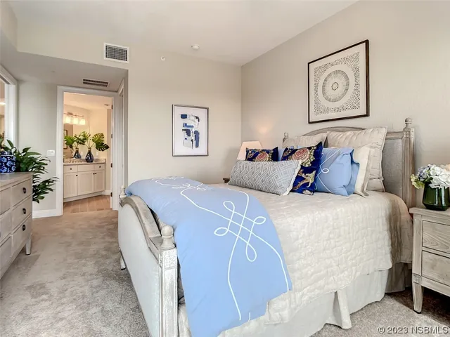 a bedroom with bed and paintings on the wall