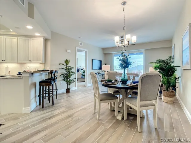 a view of a dining room with furniture wooden floor and chandelier