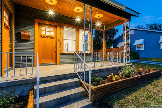 a front view of a house with a small yard and wooden fence