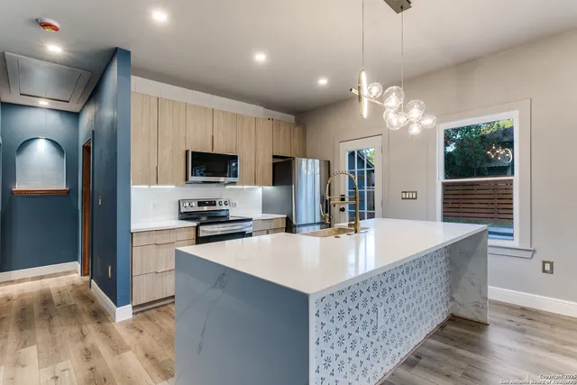 a large kitchen with kitchen island a large island in it