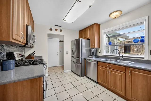 a kitchen with stainless steel appliances granite countertop a stove a sink and a microwave