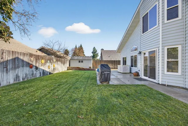 a view of a house with backyard and a tree