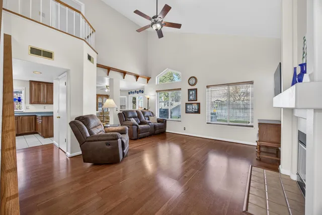 a view of an empty room with wooden floor fireplace and a window
