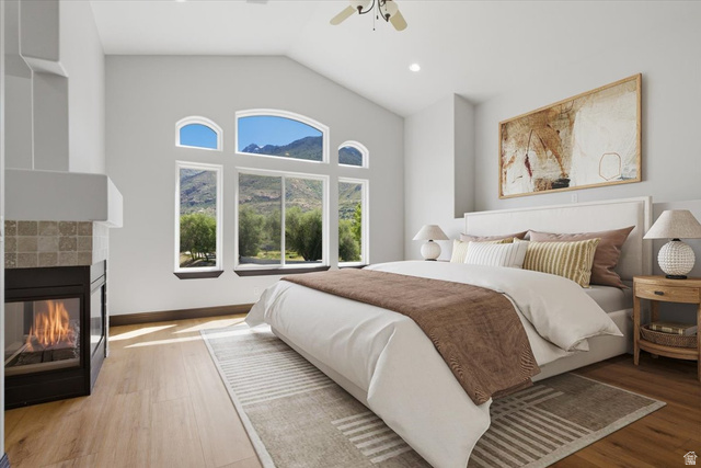 12317 Cypress Point Way Draper, UT 84020 - Photo 16 of 41 Vaulted ceiling master bedroom featuring large windows, a fireplace with a tiled surround, wood-finish flooring, and recessed lighting