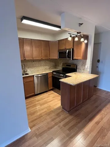 a kitchen with stainless steel appliances granite countertop a stove a sink and a microwave