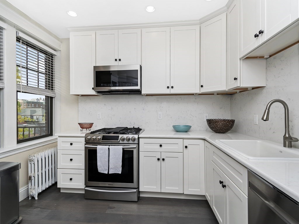 31 Winslow Road, Unit 6 Brookline, MA 02446 - Photo 8 of 18 a kitchen with white cabinets and white appliances
