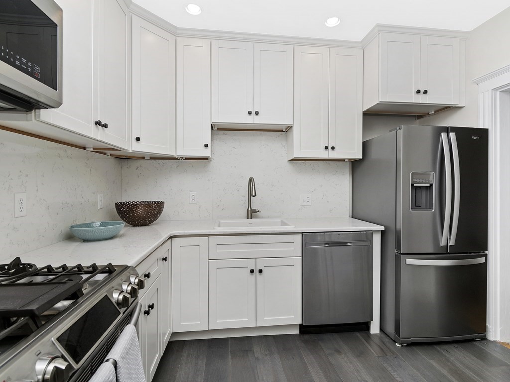31 Winslow Road, Unit 6 Brookline, MA 02446 - Photo 9 of 18 a kitchen with stainless steel appliances granite countertop a stove and a refrigerator