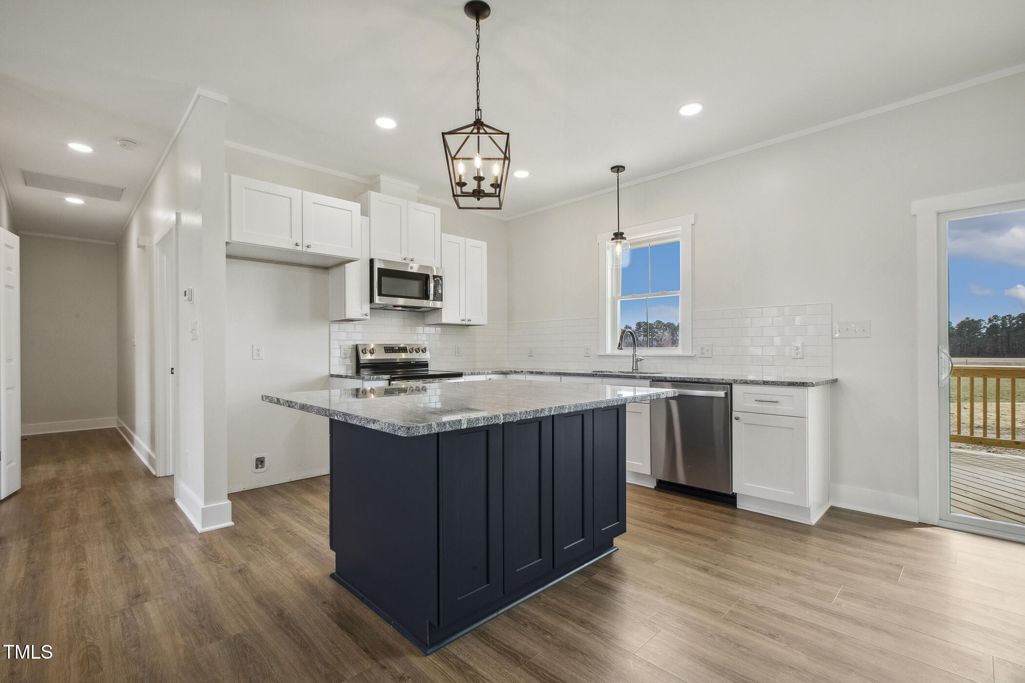 233 Surles Road Benson, NC 27504 - Photo 14 of 57 a kitchen with stainless steel appliances granite countertop wooden floors and white cabinets