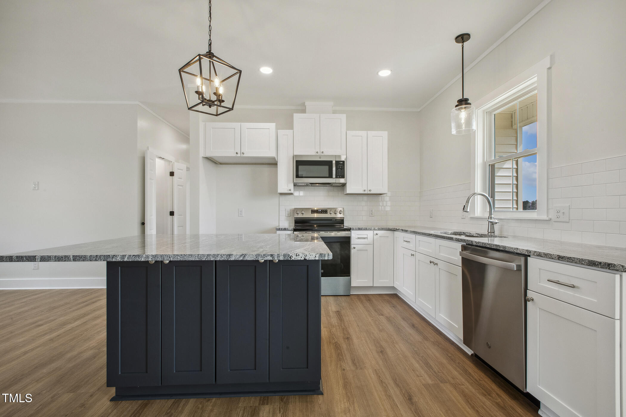 233 Surles Road Benson, NC 27504 - Photo 15 of 57 a kitchen with cabinets wooden floor and stainless steel appliances