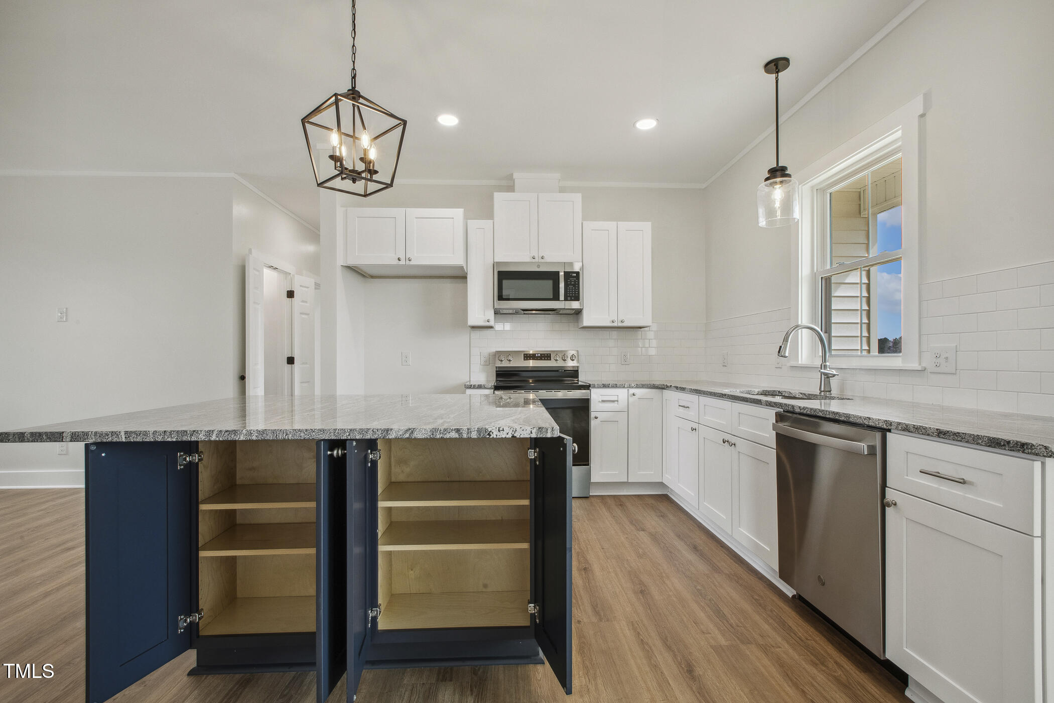233 Surles Road Benson, NC 27504 - Photo 16 of 57 a kitchen with cabinets wooden floor and stainless steel appliances