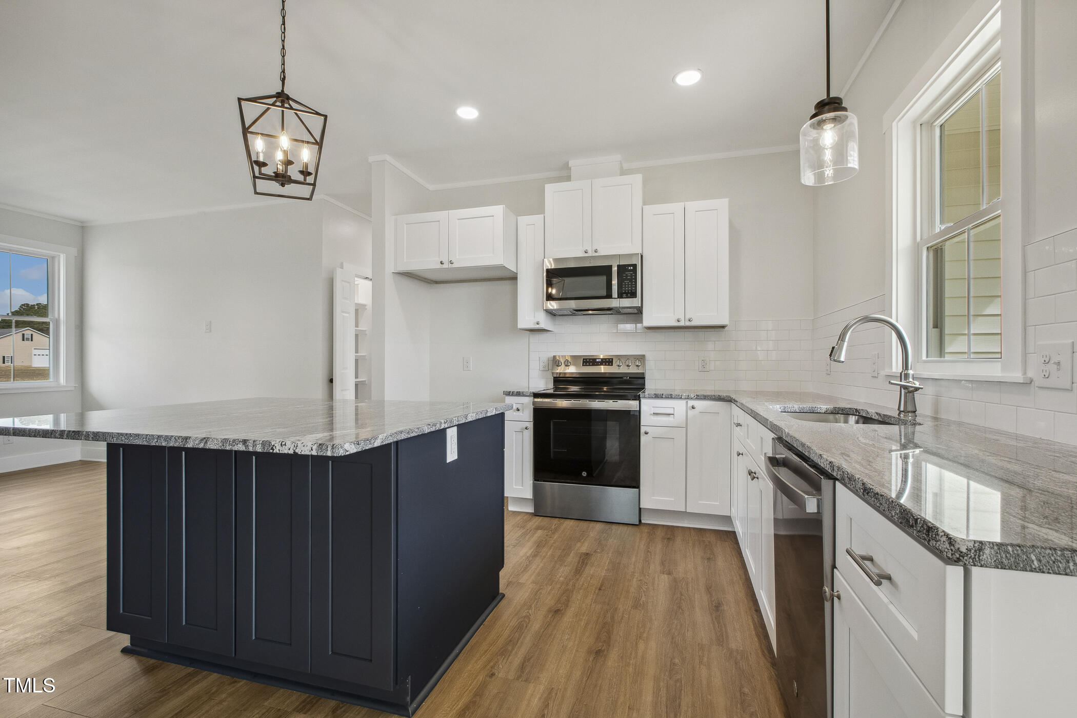 233 Surles Road Benson, NC 27504 - Photo 17 of 57 a kitchen with kitchen island granite countertop a sink and steel appliances