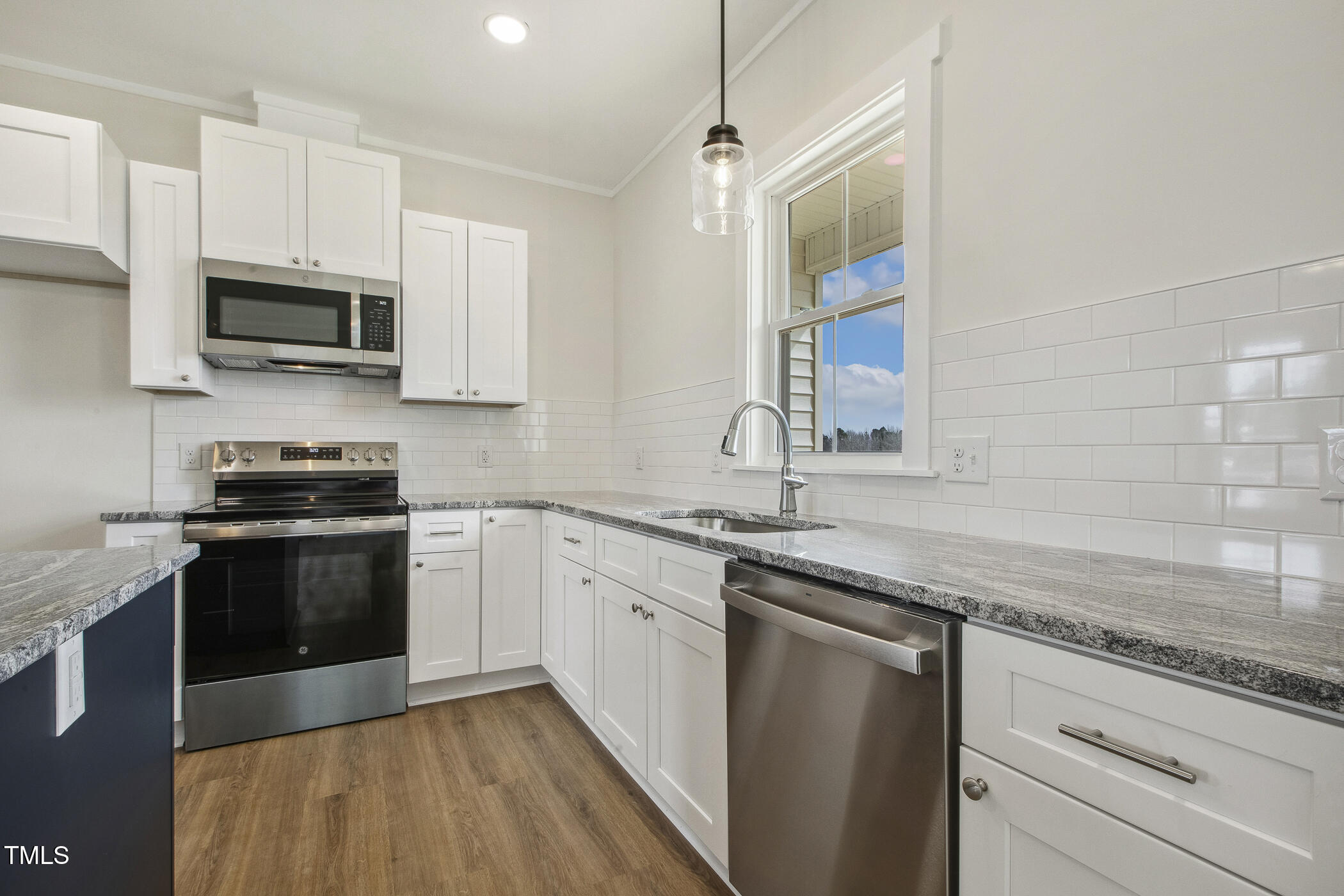 233 Surles Road Benson, NC 27504 - Photo 18 of 57 a kitchen with stainless steel appliances granite countertop a sink stove and microwave