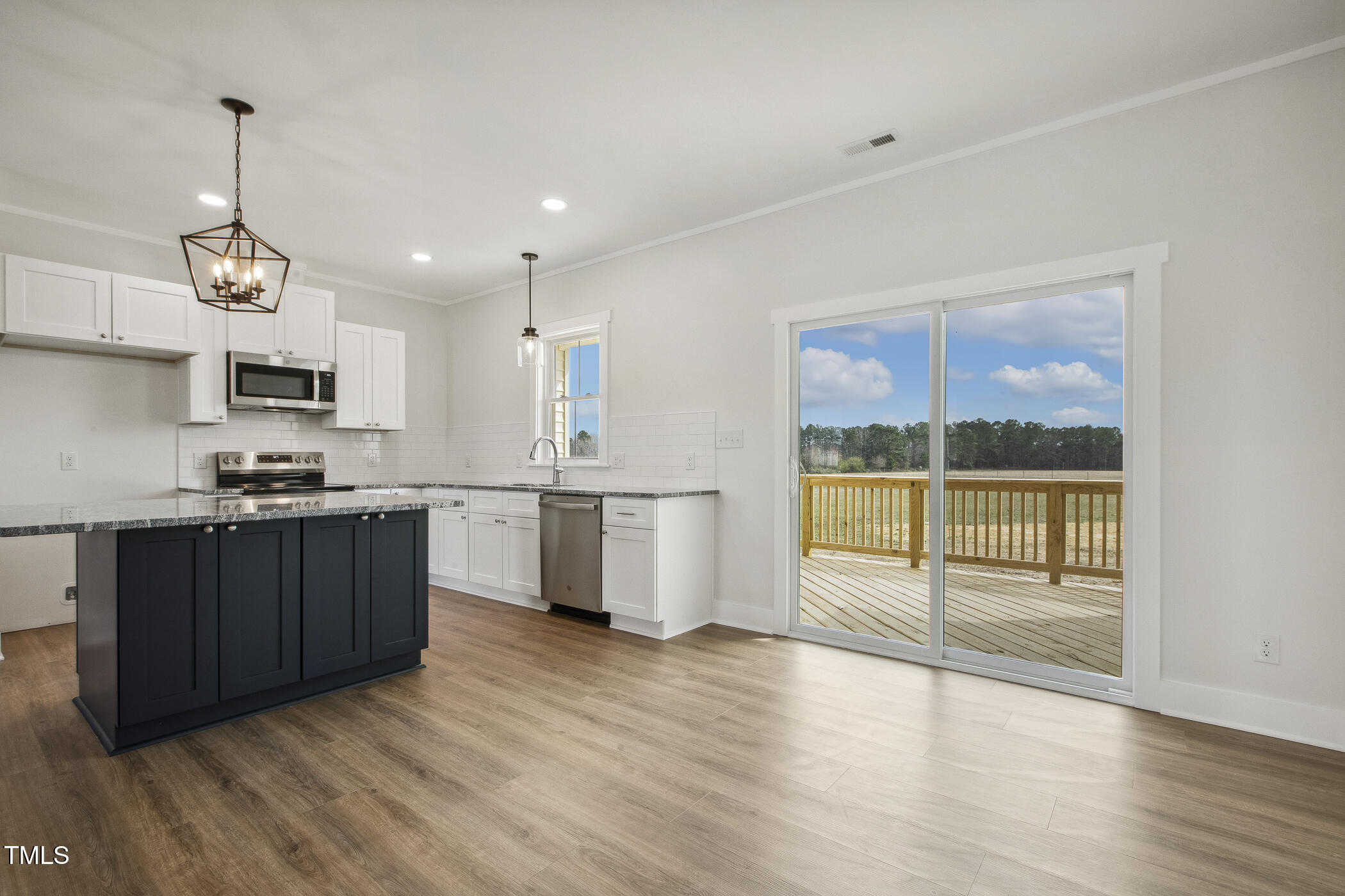 233 Surles Road Benson, NC 27504 - Photo 24 of 57 a kitchen with stainless steel appliances granite countertop a stove a sink and a large window