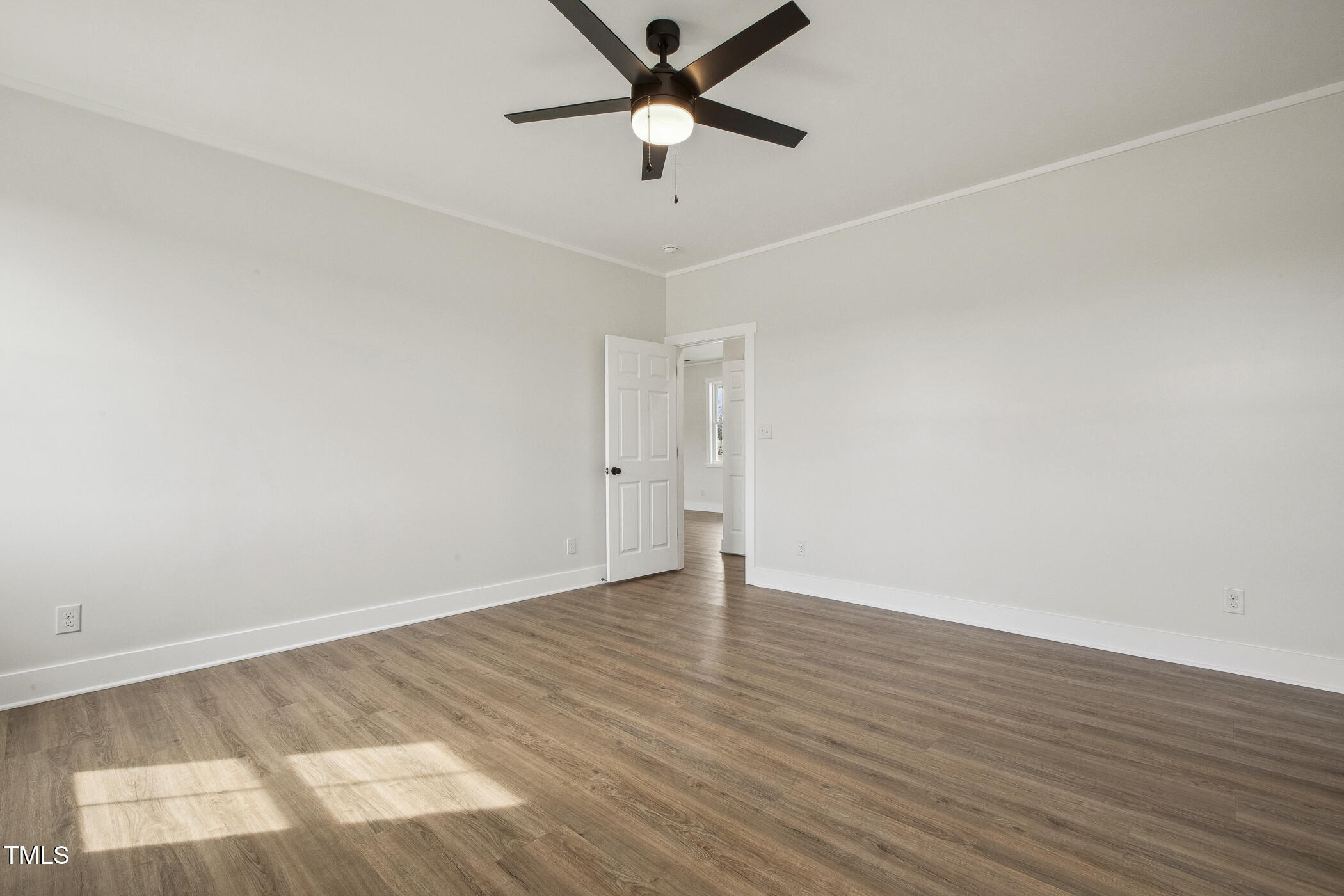 233 Surles Road Benson, NC 27504 - Photo 29 of 57 an empty room with wooden floor and a ceiling fan