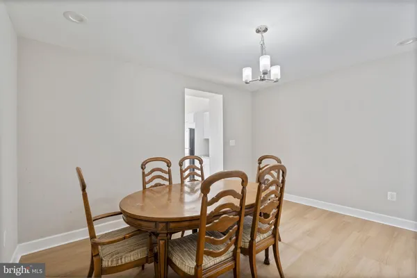 a view of a dining room with furniture a chandelier and wooden floor