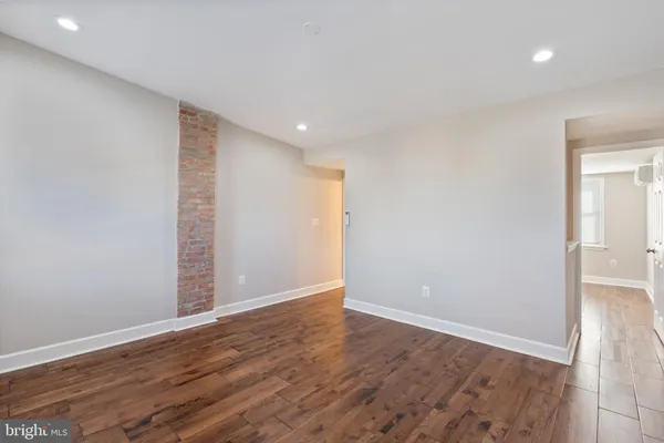 a view of an empty room with wooden floor