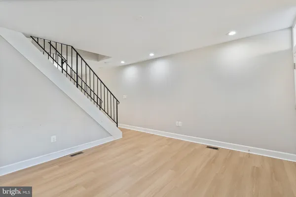 a view of room with stairs and wooden floor