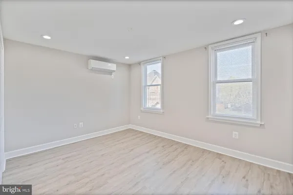 a view of an empty room with wooden floor and closet