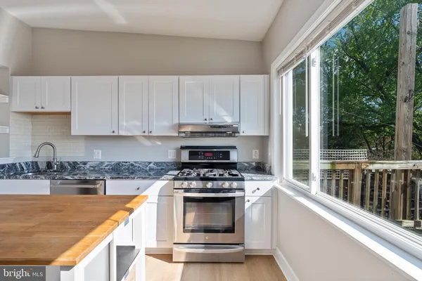 a kitchen with appliances a sink and cabinets