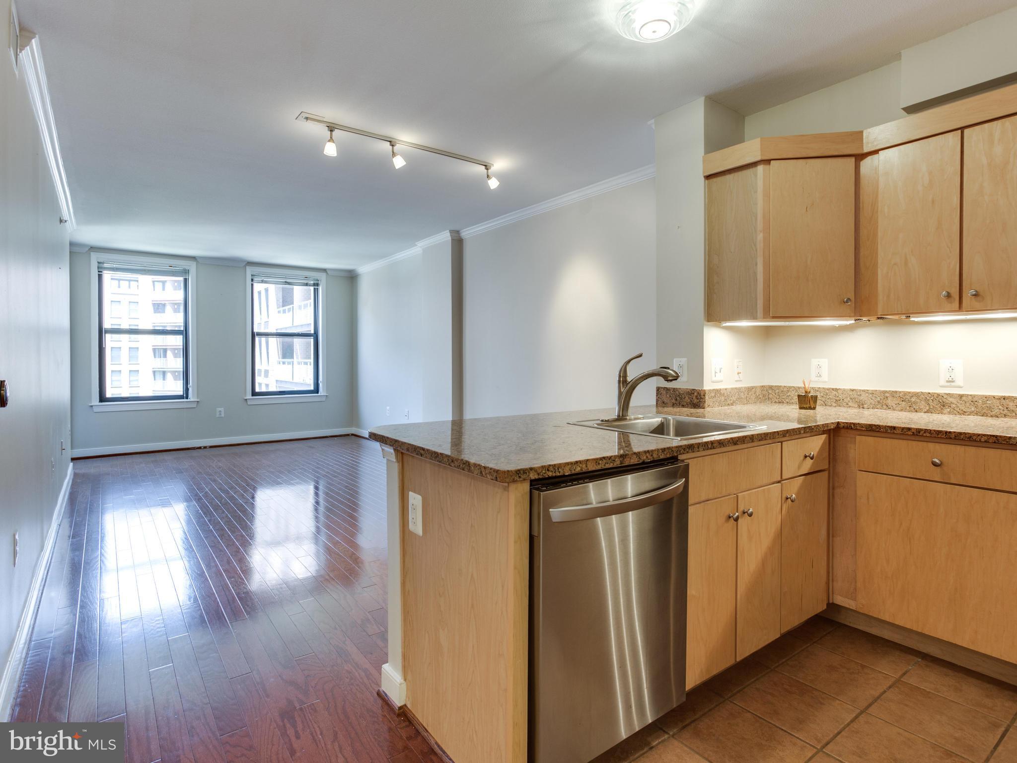631 D Street Northwest, Unit 837 Washington, DC 20004 - Photo 2 of 29 a kitchen with stainless steel appliances granite countertop a sink and wooden cabinets