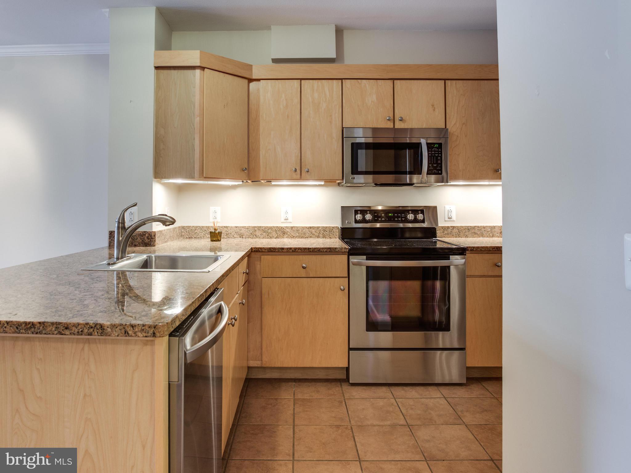 631 D Street Northwest, Unit 837 Washington, DC 20004 - Photo 3 of 29 a kitchen with granite countertop a stove sink and cabinets