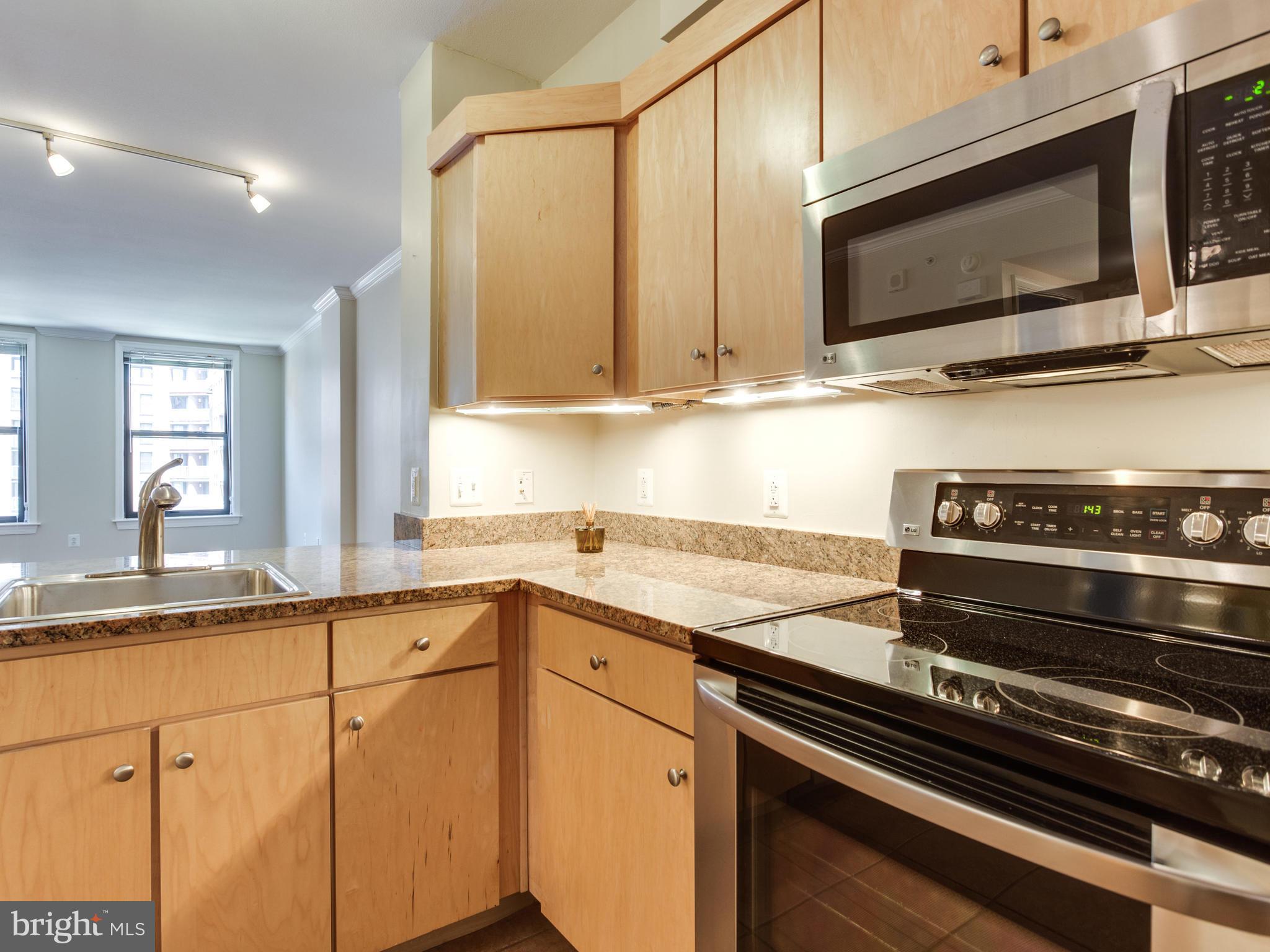 631 D Street Northwest, Unit 837 Washington, DC 20004 - Photo 5 of 29 a kitchen with stainless steel appliances granite countertop a sink stove and microwave