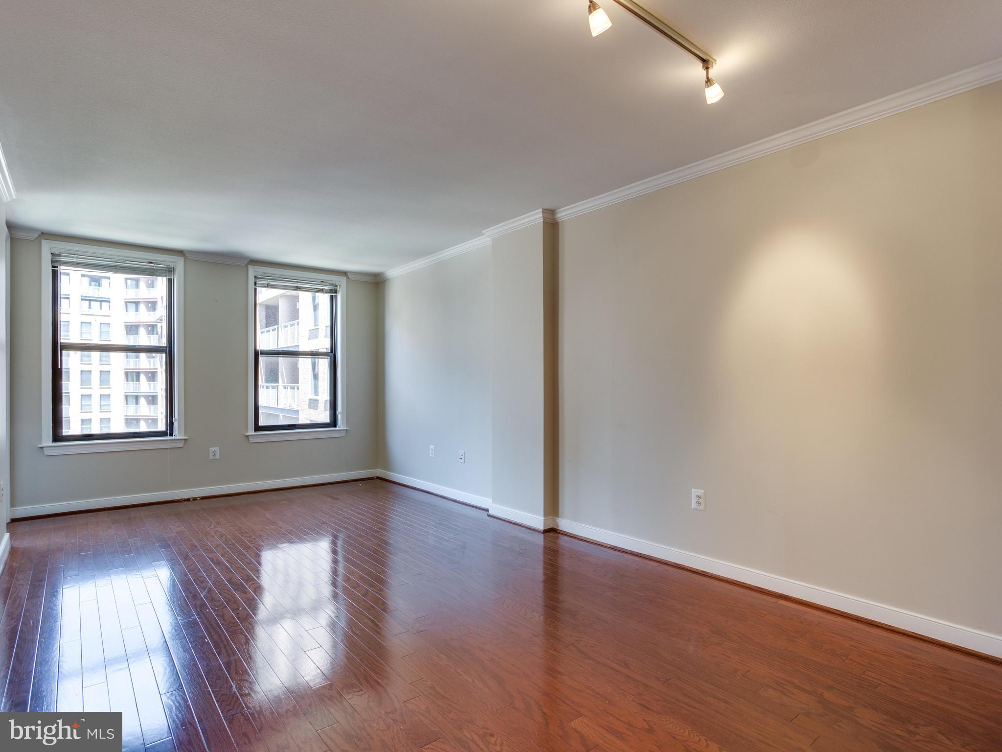 631 D Street Northwest, Unit 837 Washington, DC 20004 - Photo 6 of 29 an empty room with wooden floor and windows