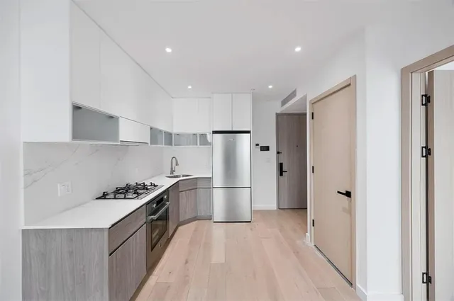 a kitchen with stainless steel appliances a refrigerator and a stove top oven