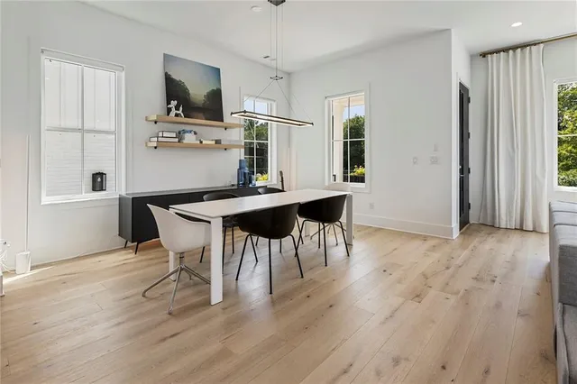 a kitchen with a table chairs a stove a window and dining table