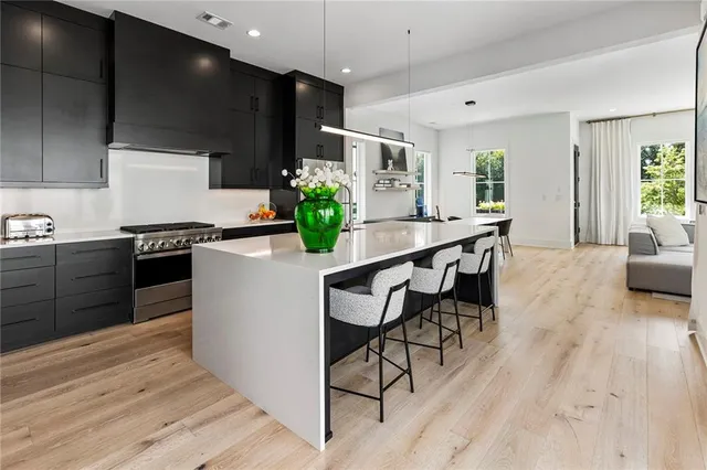 a kitchen with stainless steel appliances kitchen island granite countertop a stove a sink and a refrigerator