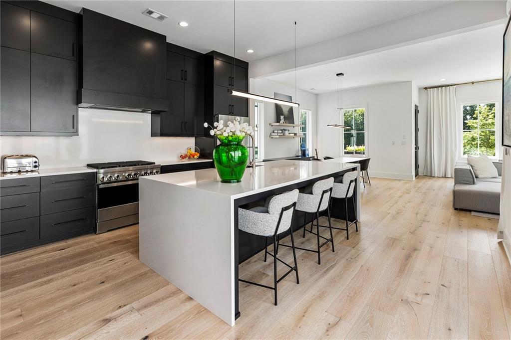 6715 Halcyon Way Alpharetta, GA 30005 - Photo 2 of 60 a kitchen with stainless steel appliances kitchen island granite countertop a stove a sink and a refrigerator