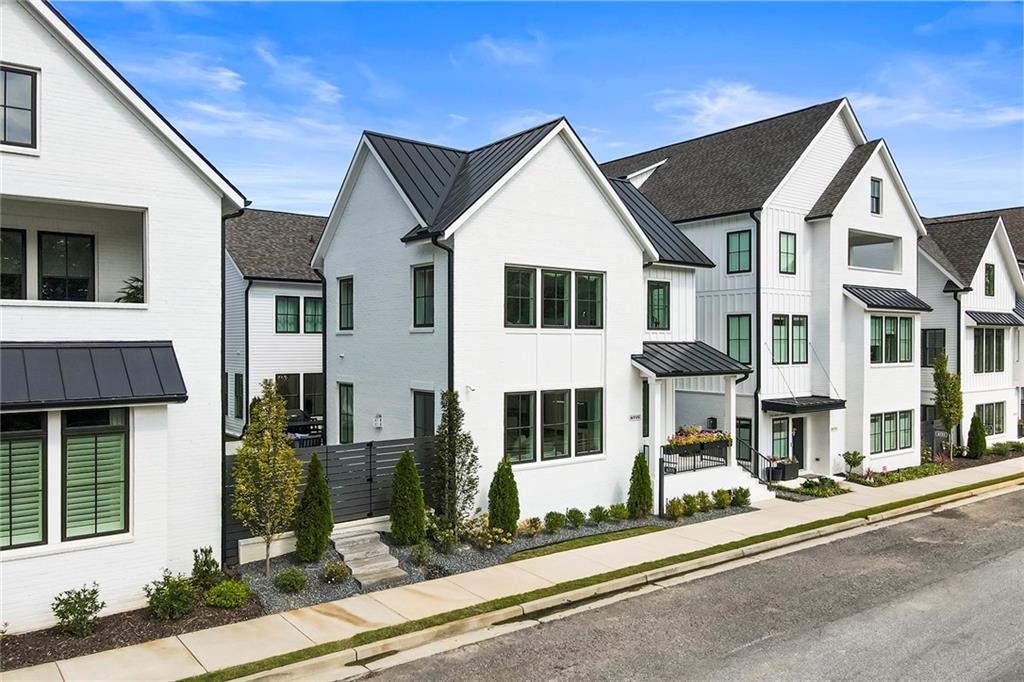 6715 Halcyon Way Alpharetta, GA 30005 - Photo 48 of 60 a view of a white house with large windows and a small yard