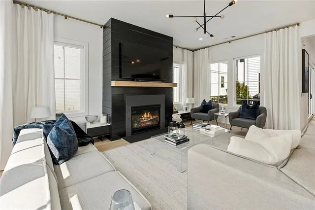a living room with furniture kitchen view and a chandelier
