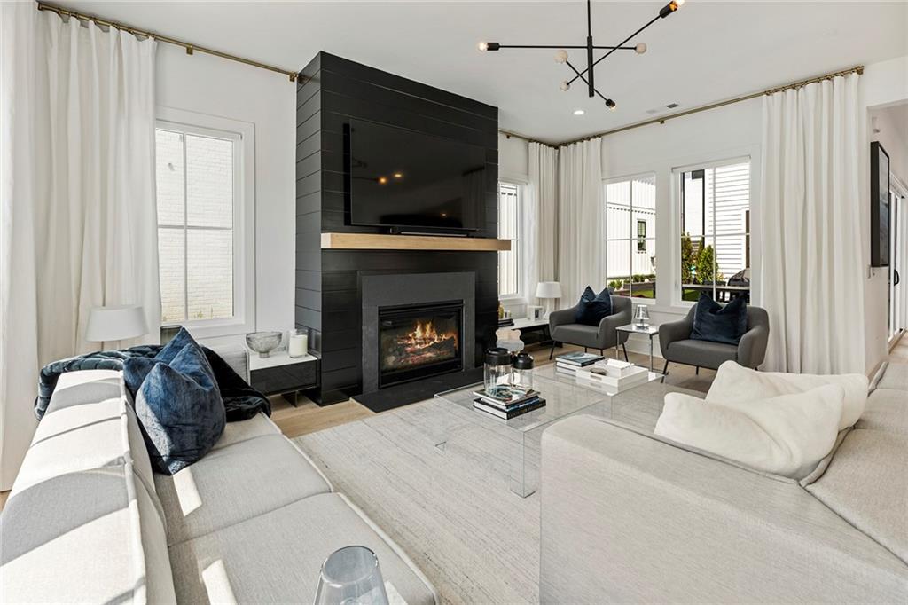 6715 Halcyon Way Alpharetta, GA 30005 - Photo 10 of 60 a living room with furniture a flat screen tv and a fireplace