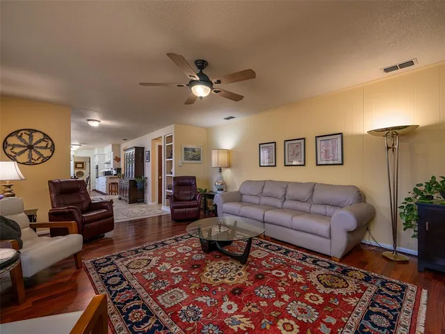 a view of a dining room and livingroom with furniture wooden floor a chandelier